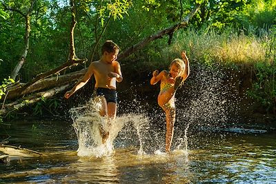 Des enfants s'éclaboussent dans une rivière 