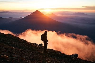 Randonneur face aux volcans du Guatemala au lever du soleil - Guatemala