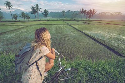 Femme à vélo dans les rizières