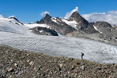 Randonneur marchant sur une moraine près du glacier du Rutor (ou Ruitor) - Vallée d'Aoste - Italie