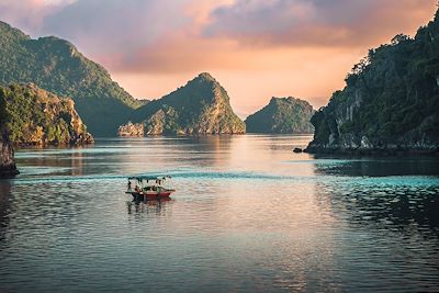 Bateau sur la baie d'halong au coucher du soleil