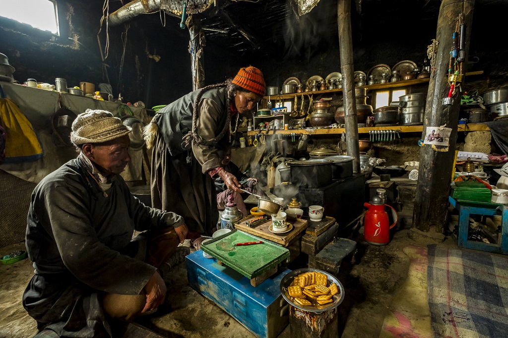Hospitalité toute ladakhie dans la demeure enfumée et "dans son jus" de Siri Angchuk et son épouse Kunzes Dolma, en train de servir le thé au beurre salé à un photographe de passage - ©Franck Charton Hospitalité toute ladakhie dans la demeure enfumée et "dans son jus" de Siri Angchuk et son épouse Kunzes Dolma, en train de servir le thé au beurre salé à un photographe de passage